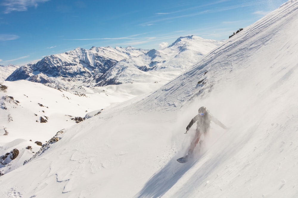 person walking on snow covered mountain during daytime