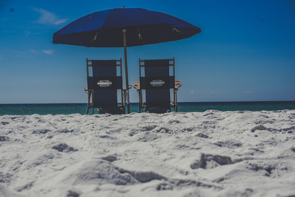 ombrello nero e marrone sulla spiaggia di sabbia bianca durante il giorno