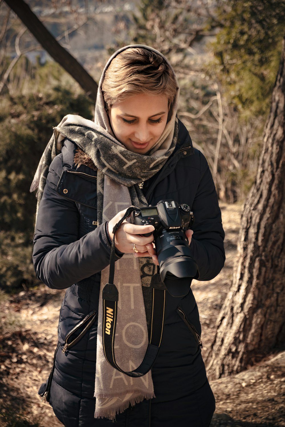 woman in black jacket holding black dslr camera