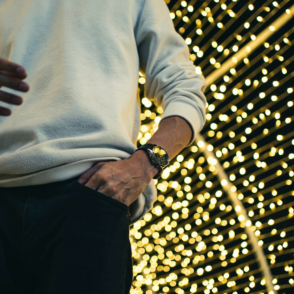 person in white long sleeve shirt and black pants wearing gold watch