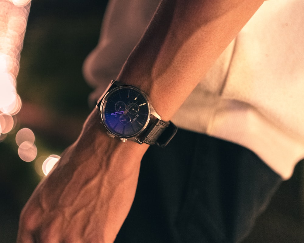 person wearing black analog watch