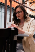 woman in white blazer holding iphone