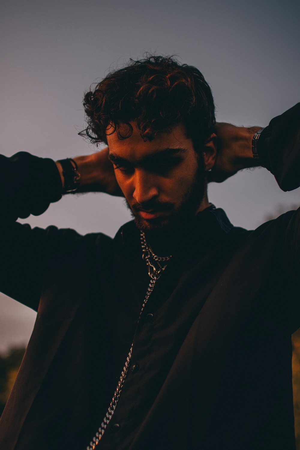 man in black coat wearing silver necklace