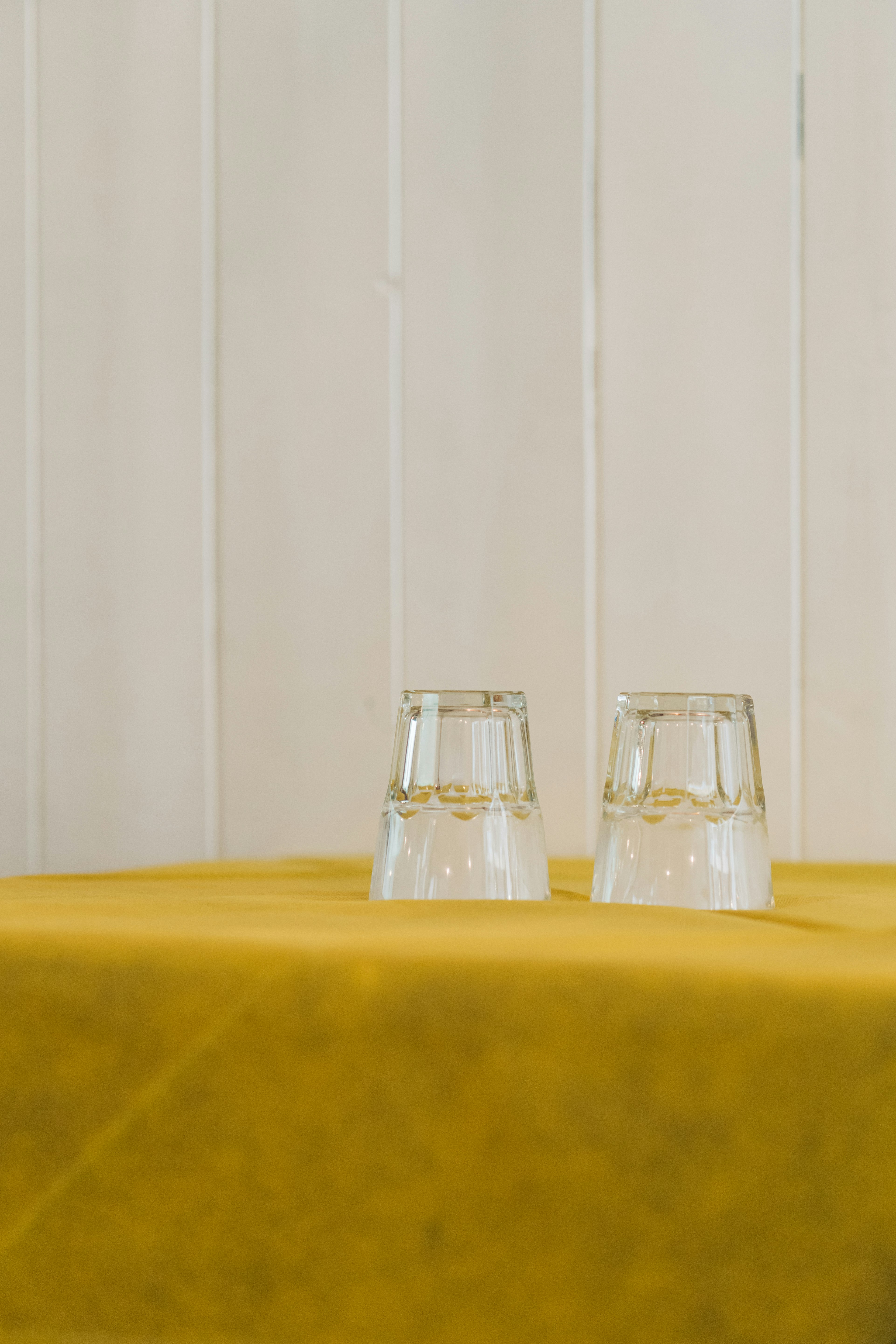 2 clear glass bottles on yellow table