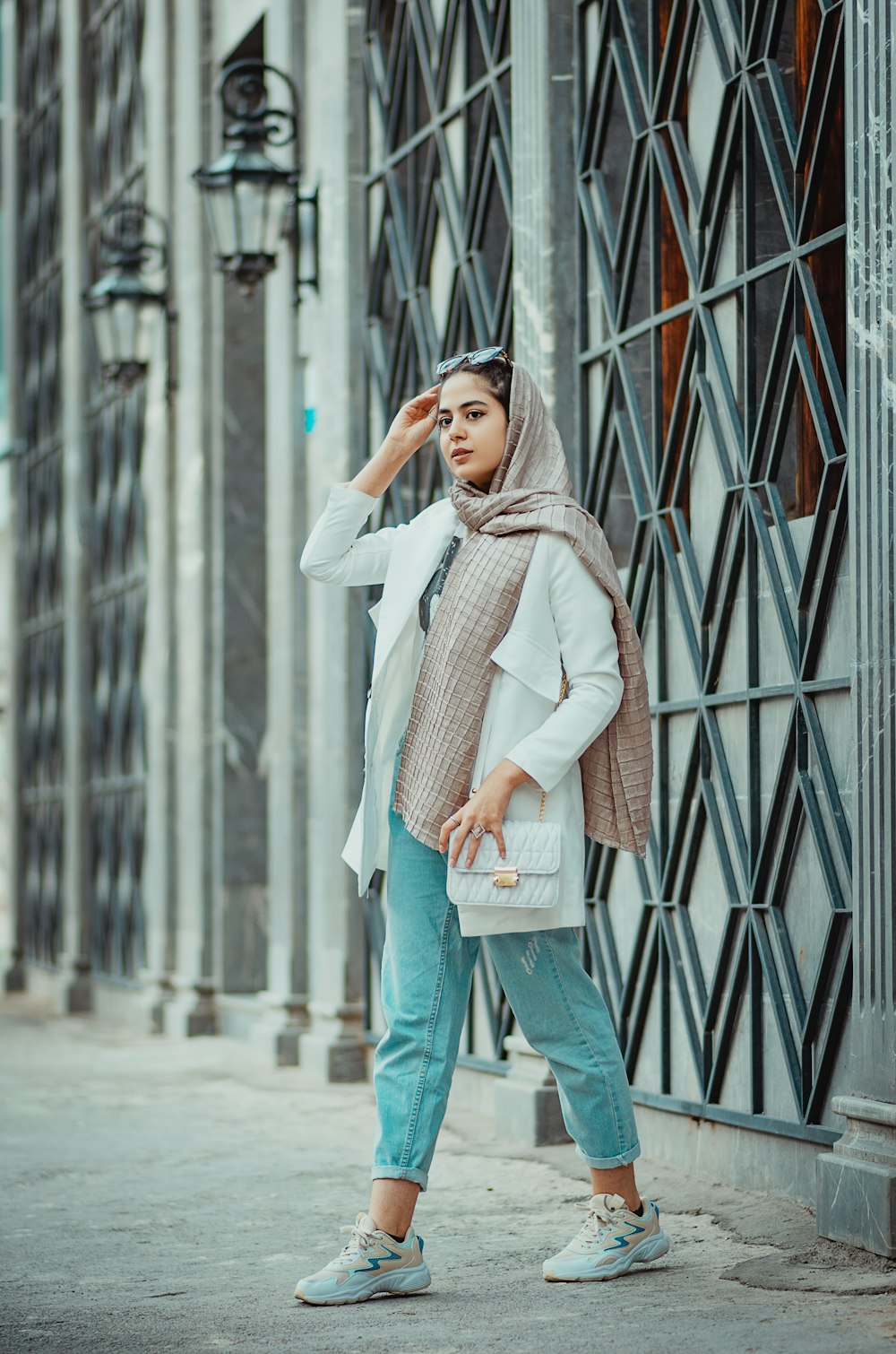 Femme en pull blanc et jean bleu debout sur le couloir