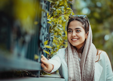 smiling girl in white long sleeve shirt and brown scarf