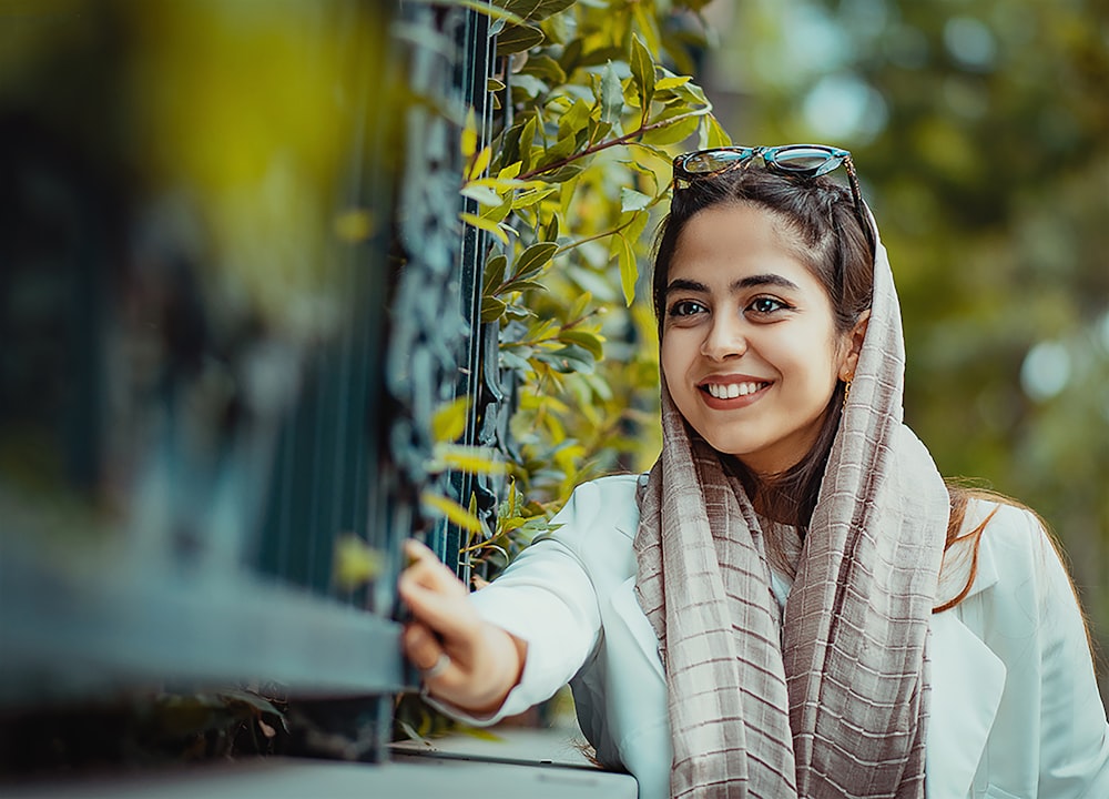 smiling girl in white long sleeve shirt and brown scarf