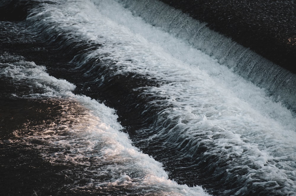 water waves hitting brown rock