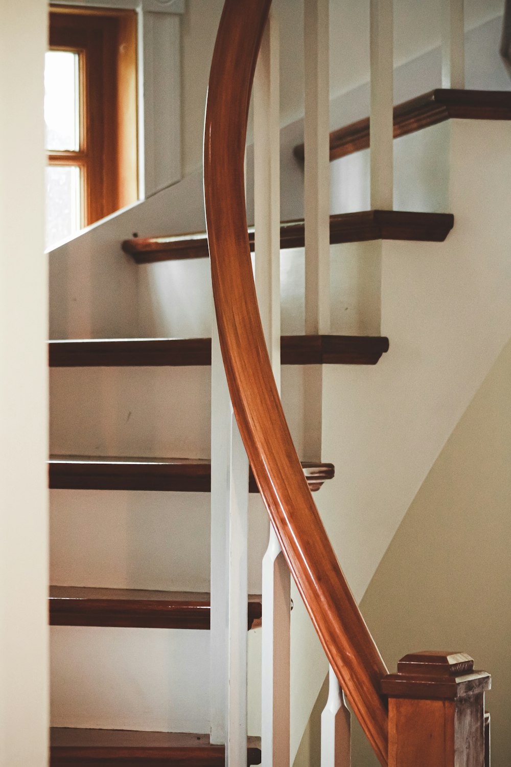 Escalera de madera marrón con pared blanca