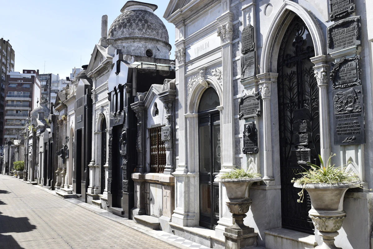A paved lane lined with ornate marble mausoleums in Recoleta Cemetery