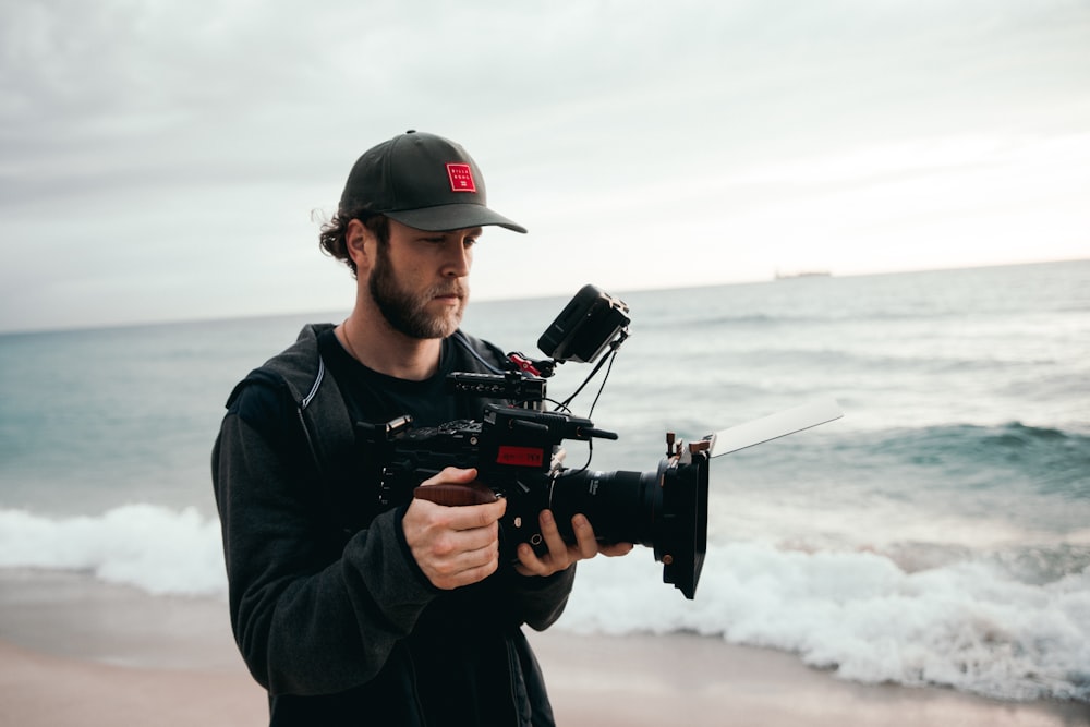 man in black jacket holding black video camera