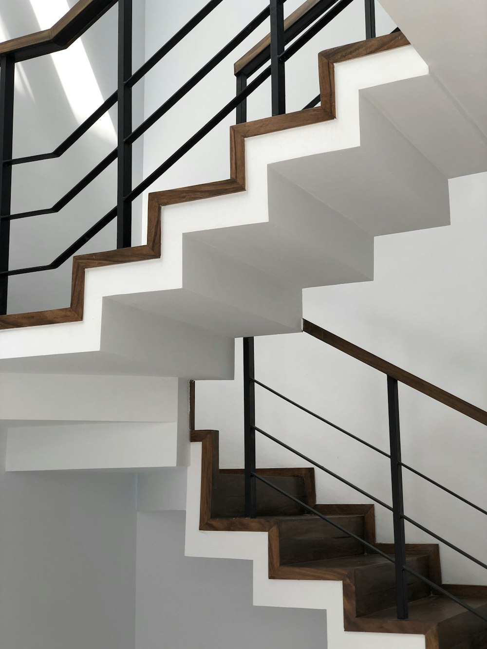 검은 금속 난간이 있는 흰색 콘크리트 계단