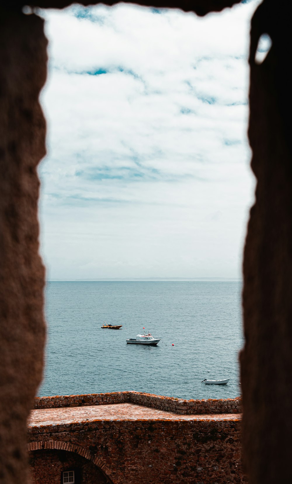 white boat on sea under white clouds during daytime