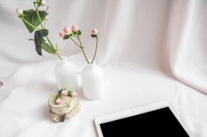 white ceramic vase with red roses