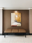 brown wooden framed painting on white wall