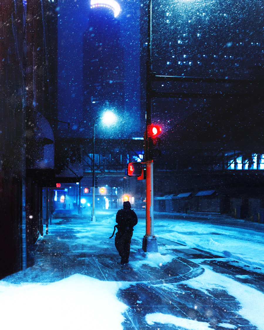A figure walking down a snowy street at night under blue light
