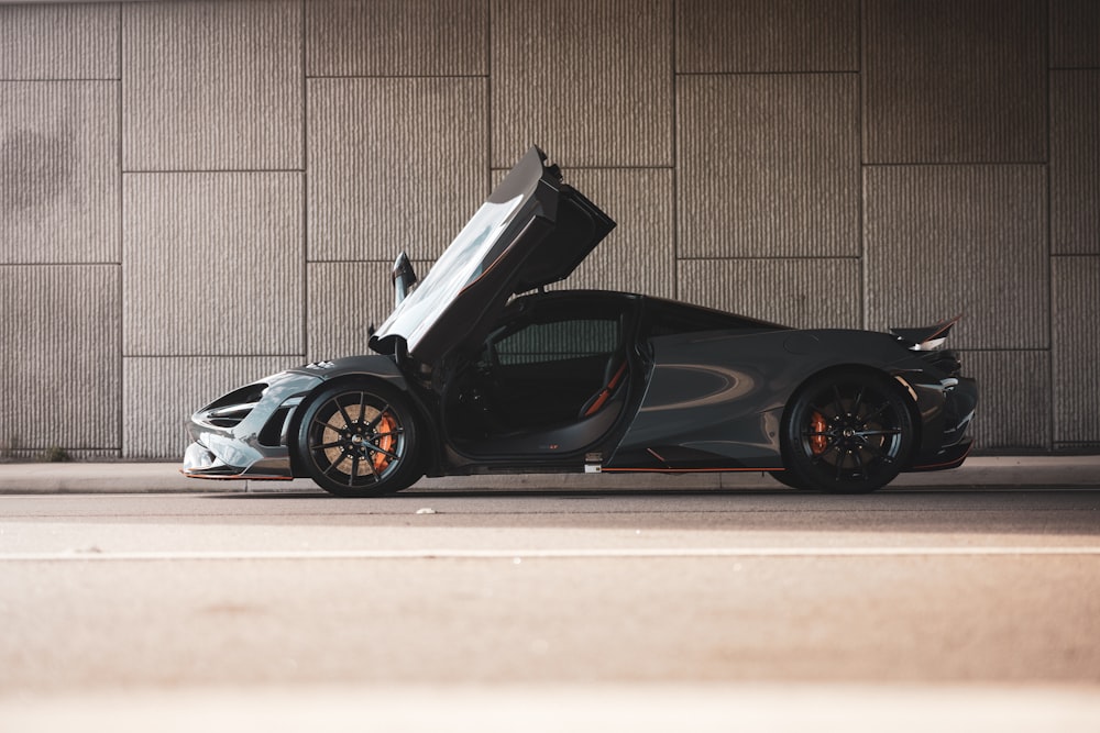 black ferrari 458 italia parked beside brown wall