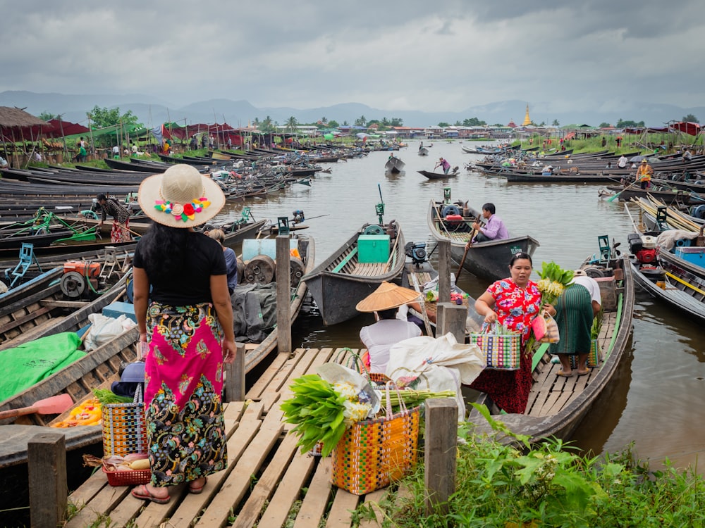 woman in black and pink floral dress standing on wooden dock during daytime