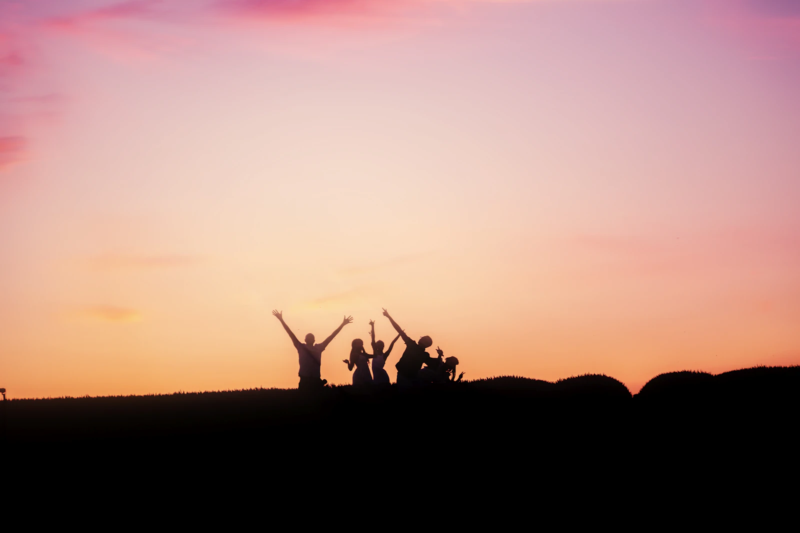 Group of hikers silhouetted on a ridge at sunset