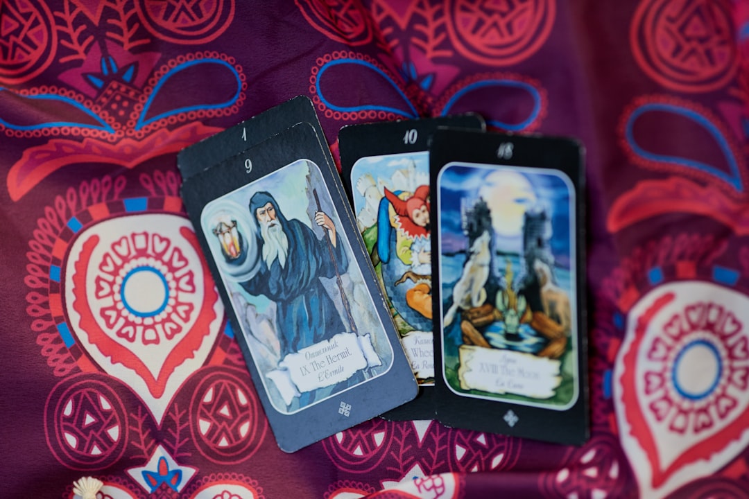 2 trading cards on red and white textile, Background with tarot cards for the site and design