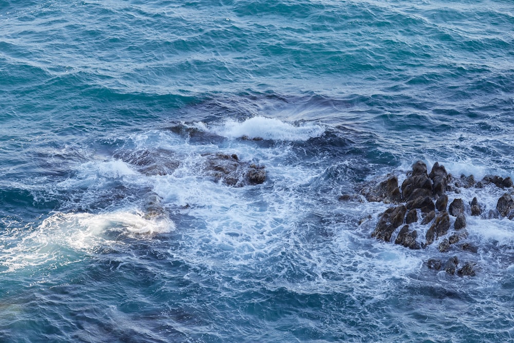 ocean waves crashing on rocks during daytime