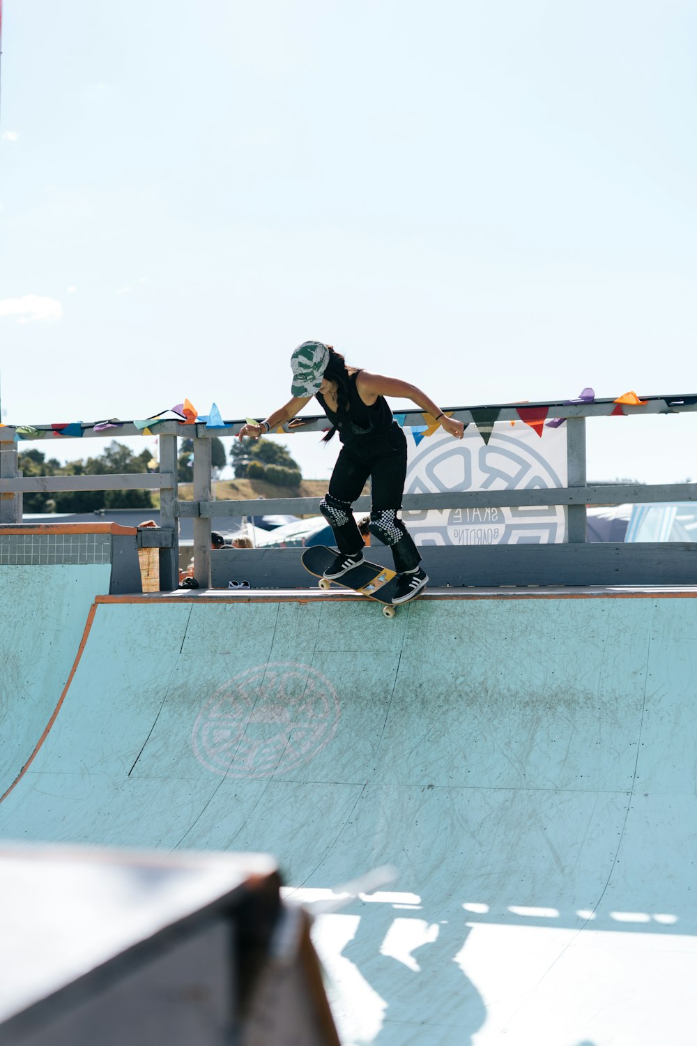 homme en débardeur noir et short noir faisant des cascades de skateboard pendant la journée