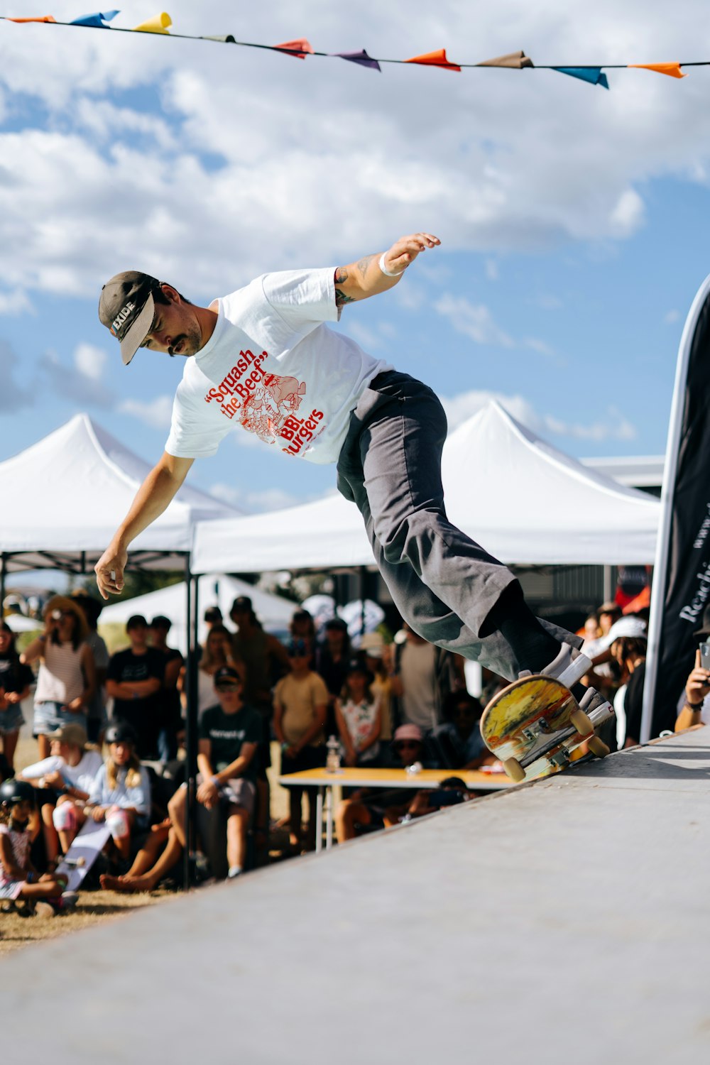 man in white t-shirt and black pants doing skateboard stunts