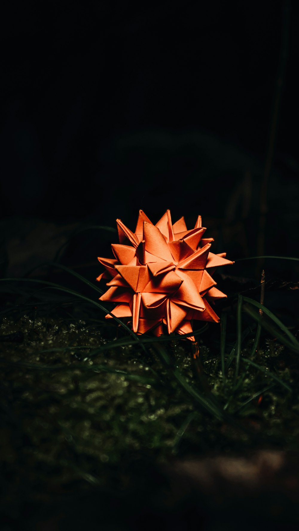 orange paper flower on green grass