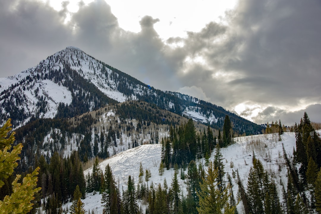 snow covered mountain under cloudy sky during daytime