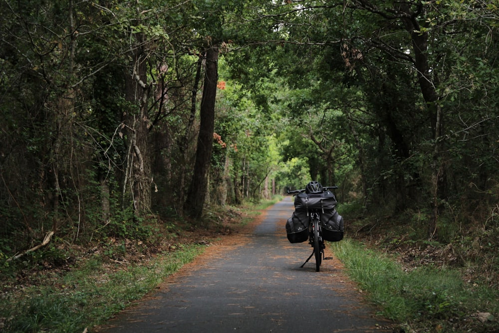 man in black jacket and black pants riding on black motorcycle on road during daytime