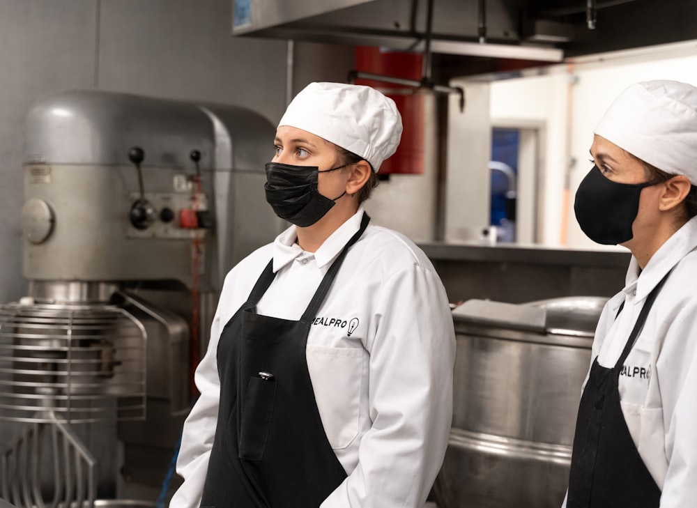 man in white chef uniform standing near stainless steel sink