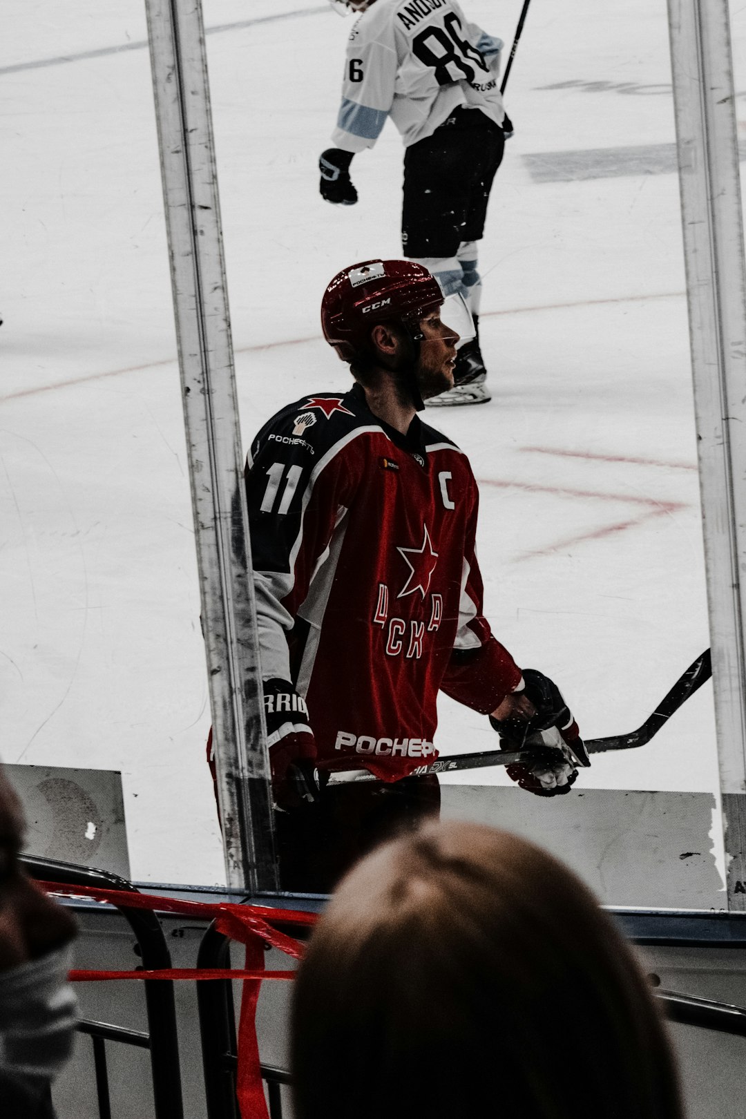 man in red and white jersey shirt playing ice hockey