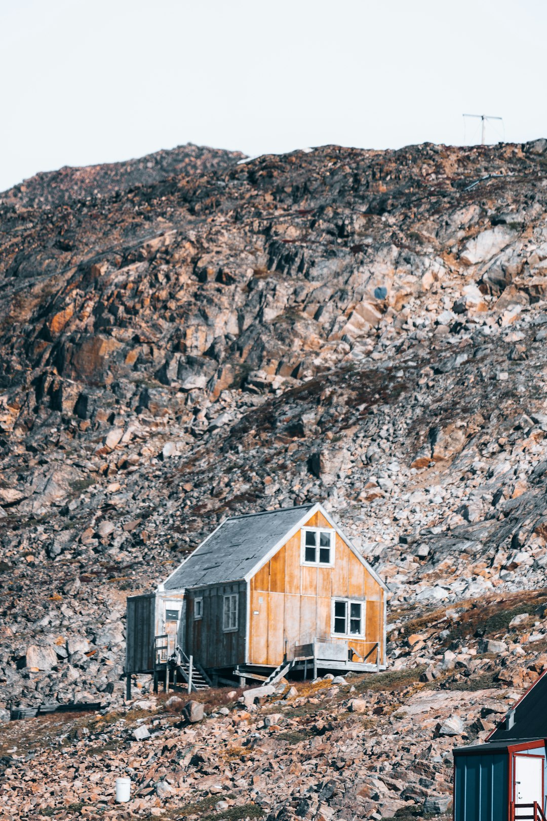 brown wooden house on rocky mountain during daytime