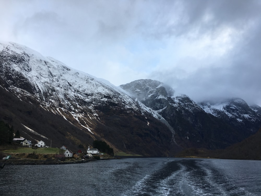 body of water near mountain during daytime