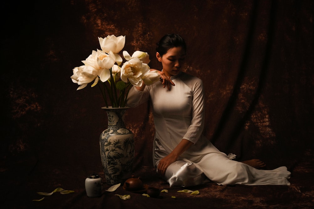 mujer en vestido de novia blanco sosteniendo ramo de flores blancas