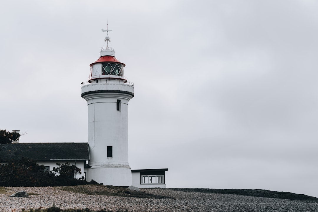 white and red lighthouse under white sky