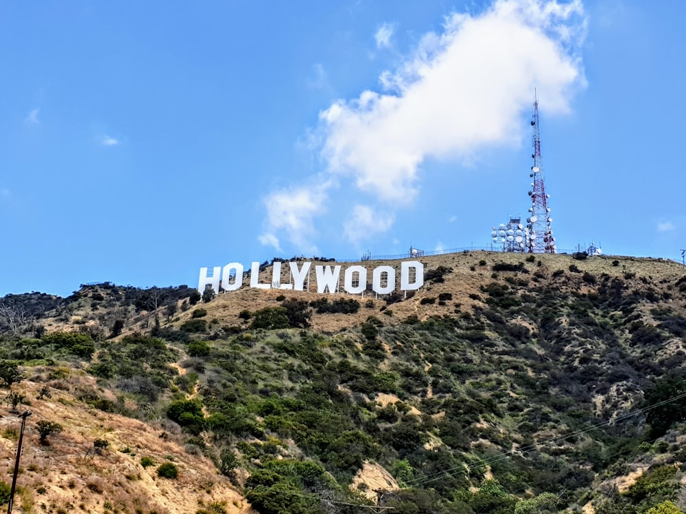 white and blue tower on brown and green mountain under blue sky during daytime