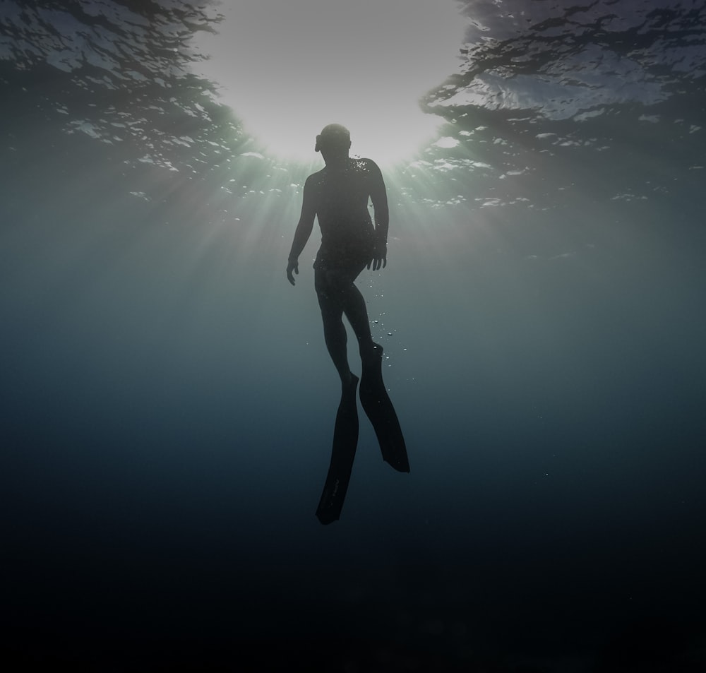 man in black shorts under water