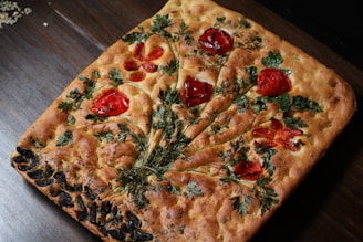 A freshly baked focaccia topped with herbs and olive oil.