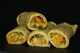 A close-up of colorful vegetable wraps with fresh herbs and light dressing.