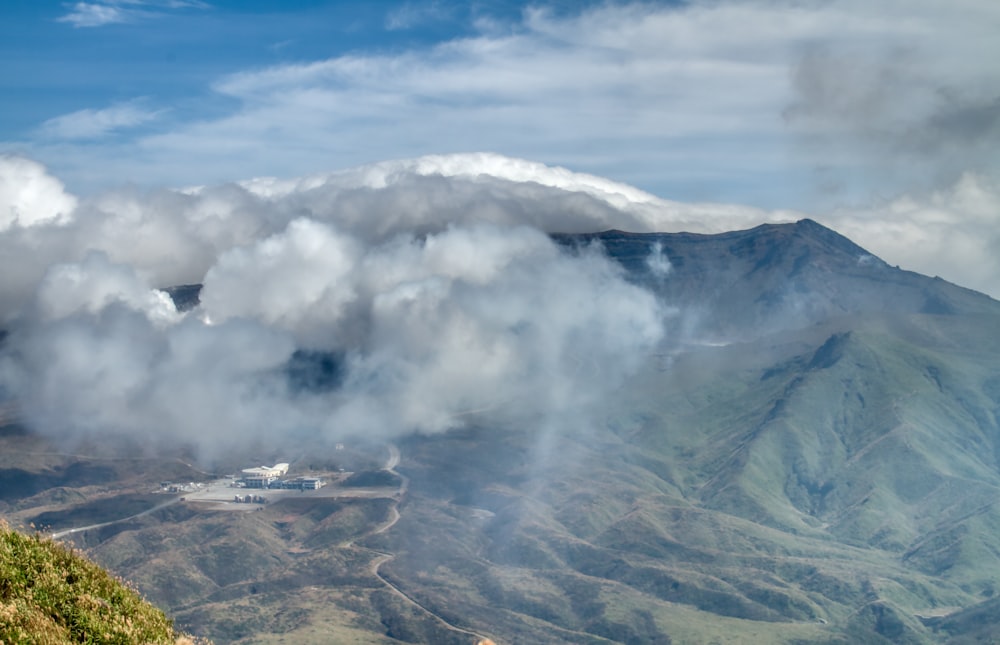 white clouds over brown mountain