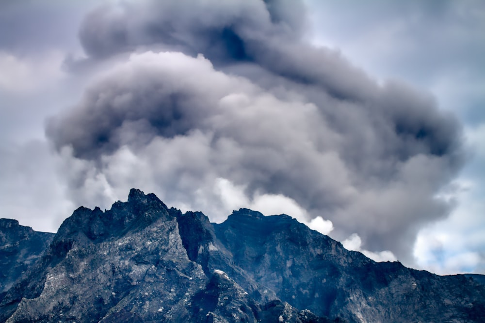 white clouds over brown and black mountain