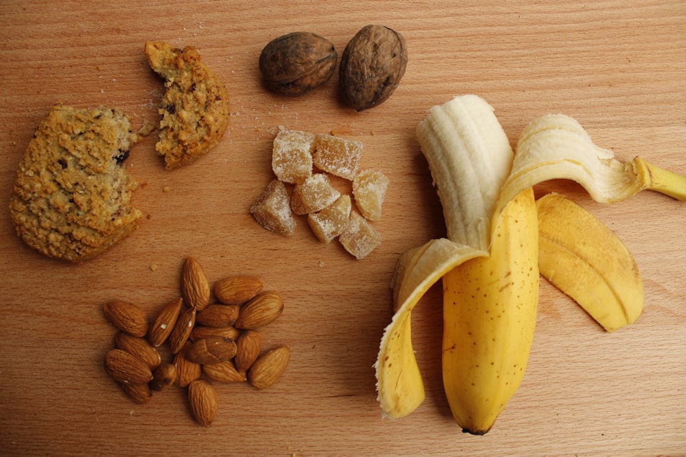 in Scheiben geschnittene Bananen und braune Nüsse auf braunem Holztisch