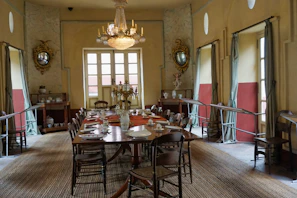 Elegant vintage dining room with dark wood paneling and antique chandeliers.