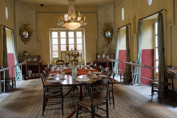 A vintage-inspired dining area with a rustic wooden table, elegant chairs, and delicate floral arrangements in muted colors.