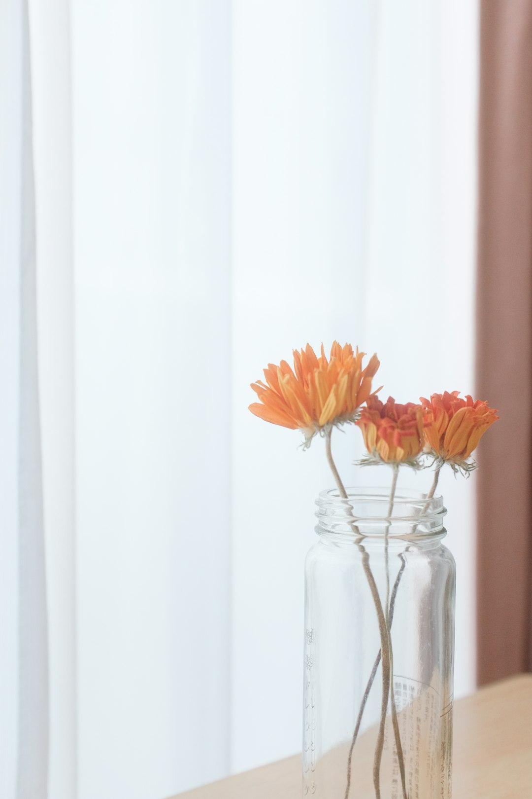 orange and yellow flowers in clear glass vase