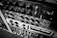 A detailed view of various audio equipment, including knobs, switches, and meters arranged in a rack. The equipment appears to be vintage audio processing units, possibly used for mixing or recording purposes.