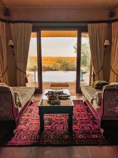 Spacious suite with Mediterranean-inspired furniture and a view of the hotel’s lush garden.