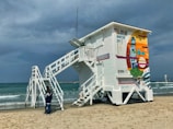 A community volunteer renovating a lifeguard tower by the beach.