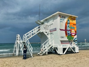 A community volunteer renovating a lifeguard tower by the beach.